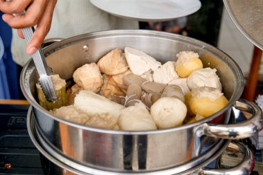 Yiyecek tedarikçileri tarafından satılan paslanmaz çelik tavalar. Acı kavun, tofu, patates ve lahana var..