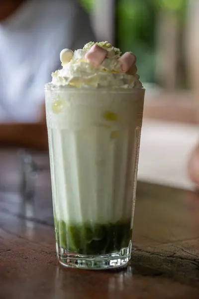 Bardağın altında avokado olan vanilyalı milkshake. Krem şanti ve lokumla kaplı..