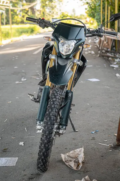 Bir Honda CRF 150L motosiklet, bir çeşit toprak motosiklet, yol kenarına park edilmişti..