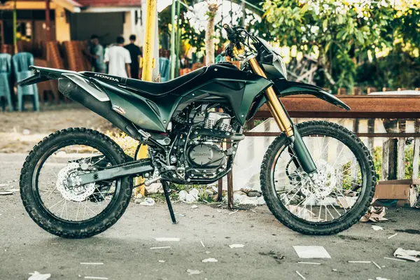 Bir Honda CRF 150L motosiklet, bir çeşit toprak motosiklet, yol kenarına park edilmişti..