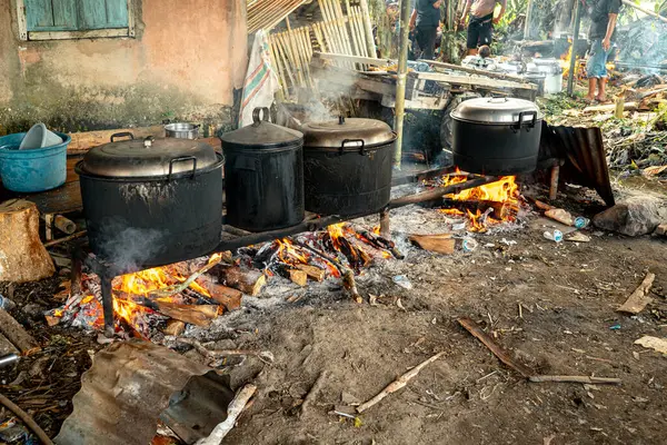 Yakacak odun kullanarak pişirme işlemi yapan dört büyük kazanla açık havada pişirme faaliyetleri.