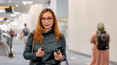 Güzel bir kadın, Sukarno-Hatta havaalanı, Jakarta 'daki varış terminalinin koridorunda yürüyor..