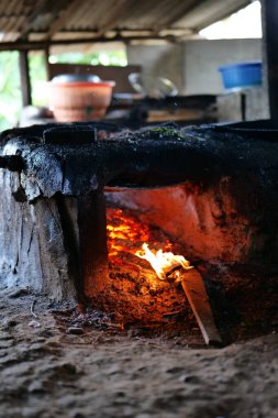 Çimentodan bir soba, yemek pişirmek için. Yemek pişirme işlemi hala yakacak odun kullanıyor..
