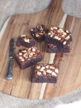 Tahta tepside servis edilen badem fıstıklı ev yapımı çikolatalı brownie.