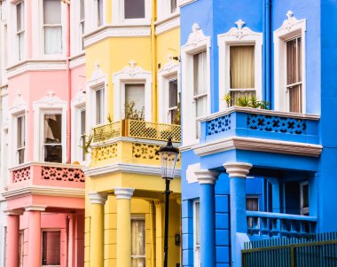 Baharda Notting Hill, Londra, İngiltere 'de üç renkli Viktorya dönemi evinin açı manzaralı sırası. Yüksek kalite fotoğraf