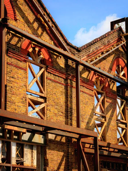 Propped-up gables of Victorian buidling with scaffolding of wooden en steel beams, waiting for reconstruction, in full sunlight in the daytime of a spring day, London, England UK. High quality photo