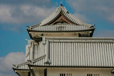 Kanazawa Kalesi 'nin görüşü, Japonya' nın feodal tarihinin ve kültürel mirasının bir sembolü. Kale beyaz alçıdan duvarlar ve çok katmanlı, kurşun kiremitli çatılar açık mavi bir gökyüzüne karşı duruyor. Şıklığın