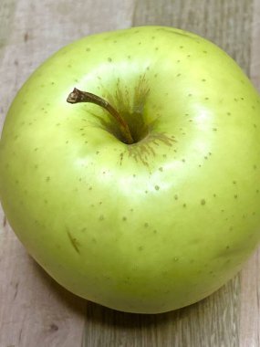 Ahşap bir tahtanın üzerinde yeşil bir elma uzanıyor mutfak, vitaminler, yararlı, sağlık, yemek, sebze, meyve, lezzetli, iştah açıcı, hayatı seviyorum, yemek pişirmeyi seviyorum..