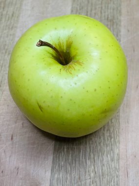 Ahşap bir tahtanın üzerinde yeşil bir elma uzanıyor mutfak, vitaminler, yararlı, sağlık, yemek, sebze, meyve, lezzetli, iştah açıcı, hayatı seviyorum, yemek pişirmeyi seviyorum..