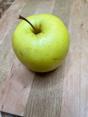 Ahşap bir tahtanın üzerinde yeşil bir elma uzanıyor mutfak, vitaminler, yararlı, sağlık, yemek, sebze, meyve, lezzetli, iştah açıcı, hayatı seviyorum, yemek pişirmeyi seviyorum..