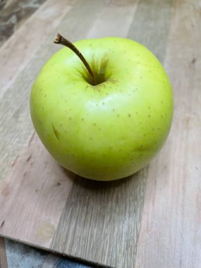 Ahşap bir tahtanın üzerinde yeşil bir elma uzanıyor mutfak, vitaminler, yararlı, sağlık, yemek, sebze, meyve, lezzetli, iştah açıcı, hayatı seviyorum, yemek pişirmeyi seviyorum..