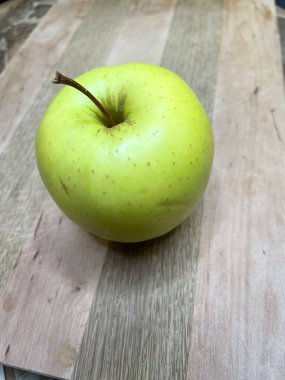 Ahşap bir tahtanın üzerinde yeşil bir elma uzanıyor mutfak, vitaminler, yararlı, sağlık, yemek, sebze, meyve, lezzetli, iştah açıcı, hayatı seviyorum, yemek pişirmeyi seviyorum..