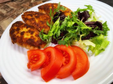 Kızarmış et pirzolası beyaz tabakta, domates, yeşillik, marul, salata, kahvaltı, öğle yemeği, protein, kalori, mutfak, yemek, tavuk, domuz eti, dana eti, et, kızartma, yemek, aşk, yaşam, yeşil, kırmızı