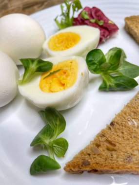 Kahvaltı, aperatif, yemek, yemek, mutfak tabağında haşlanmış yumurta, yumurta sarısı, yumurta beyazı, sarı, beyaz, yeşiller, marul yaprakları, tahıl, tahıl, mısır gevreği, ekmek, tost, yemek, yemek, pişirme, organik, vegan, sağlık, kalori, aşk hayatı var.