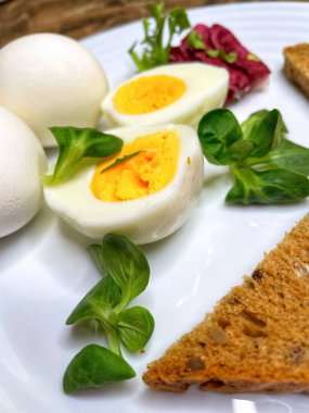 Kahvaltı, aperatif, yemek, yemek, mutfak tabağında haşlanmış yumurta, yumurta sarısı, yumurta beyazı, sarı, beyaz, yeşiller, marul yaprakları, tahıl, tahıl, mısır gevreği, ekmek, tost, yemek, yemek, pişirme, organik, vegan, sağlık, kalori, aşk hayatı var.