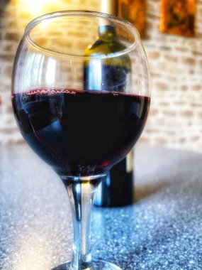 Mutfak masasında bir bardak kırmızı şarap. 