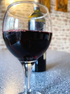 Mutfak masasında bir bardak kırmızı şarap. 