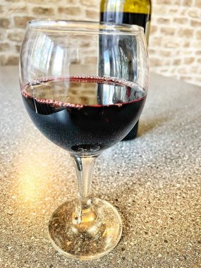 Mutfak masasında bir bardak kırmızı şarap. 