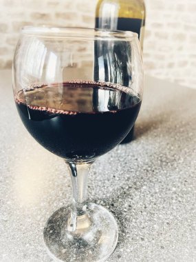 Mutfak masasında bir bardak kırmızı şarap. 