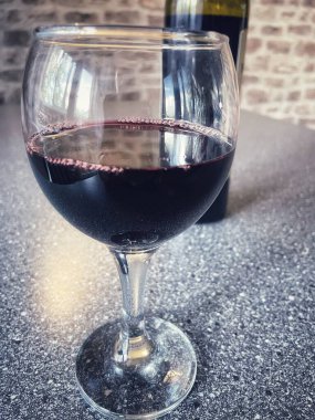 Mutfak masasında bir bardak kırmızı şarap. 