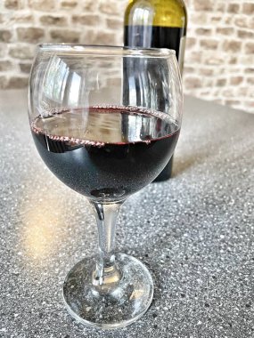 Mutfak masasında bir bardak kırmızı şarap. 