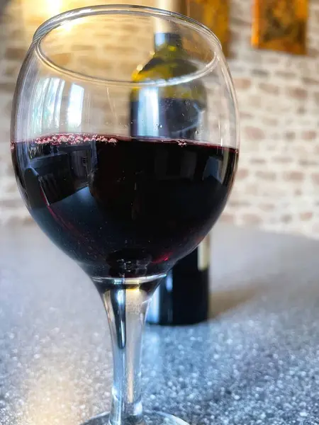 Mutfak masasında bir bardak kırmızı şarap. 