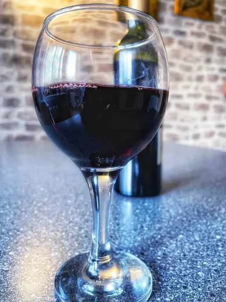 Mutfak masasında bir bardak kırmızı şarap. 