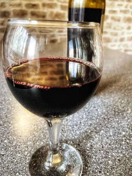 Mutfak masasında bir bardak kırmızı şarap. 