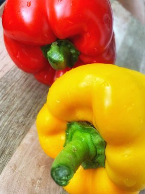 Tahta bir masada taze renkli dolmalık biber, kırmızı biber.