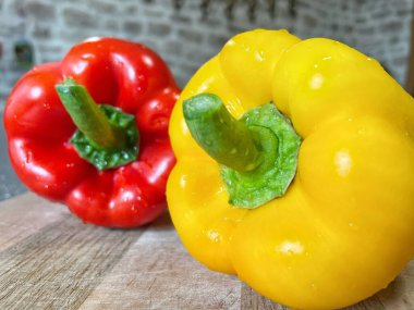 Tahta bir masada taze renkli dolmalık biber, kırmızı biber.