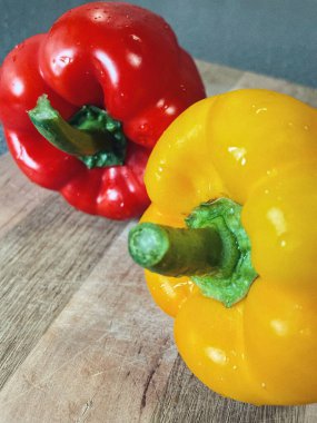 Tahta bir masada taze renkli dolmalık biber, kırmızı biber.