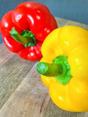 Tahta bir masada taze renkli dolmalık biber, kırmızı biber.