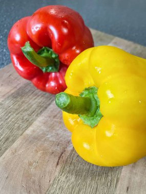 Tahta bir masada taze renkli dolmalık biber, kırmızı biber.