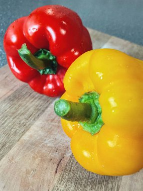 Tahta bir masada taze renkli dolmalık biber, kırmızı biber.