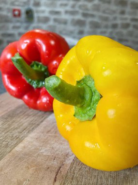 Tahta bir masada taze renkli dolmalık biber, kırmızı biber.