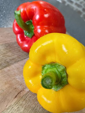 Tahta bir masada taze renkli dolmalık biber, kırmızı biber.