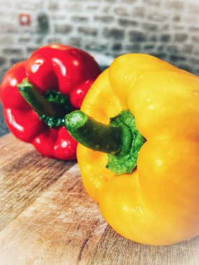 Tahta bir masada taze renkli dolmalık biber, kırmızı biber.