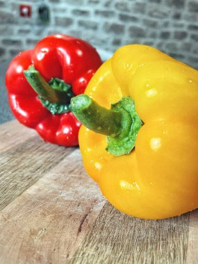 Tahta bir masada taze renkli dolmalık biber, kırmızı biber.