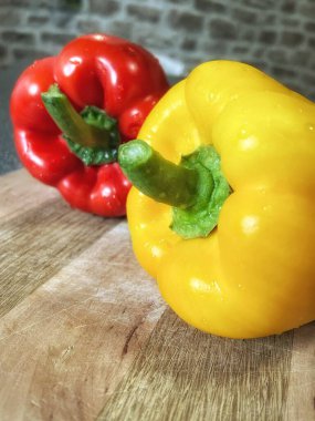 Tahta bir masada taze renkli dolmalık biber, kırmızı biber.