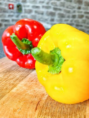 Tahta bir masada taze renkli dolmalık biber, kırmızı biber.