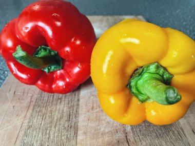 Tahta bir masada taze renkli dolmalık biber, kırmızı biber.