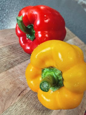 Tahta bir masada taze renkli dolmalık biber, kırmızı biber.