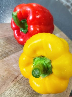 Tahta bir masada taze renkli dolmalık biber, kırmızı biber.