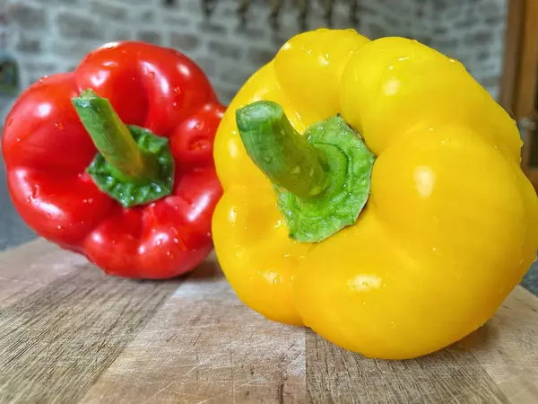 Tahta bir masada taze renkli dolmalık biber, kırmızı biber.