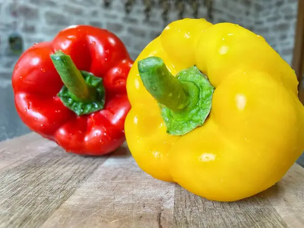 Tahta bir masada taze renkli dolmalık biber, kırmızı biber.