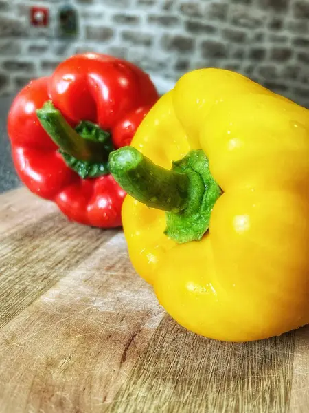 Tahta bir masada taze renkli dolmalık biber, kırmızı biber.