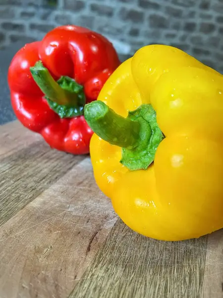 Tahta bir masada taze renkli dolmalık biber, kırmızı biber.