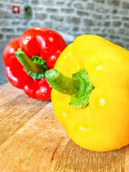 Tahta bir masada taze renkli dolmalık biber, kırmızı biber.