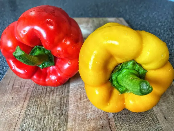 Tahta bir masada taze renkli dolmalık biber, kırmızı biber.