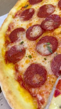 Domates, peynir ve jambonlu pizza.